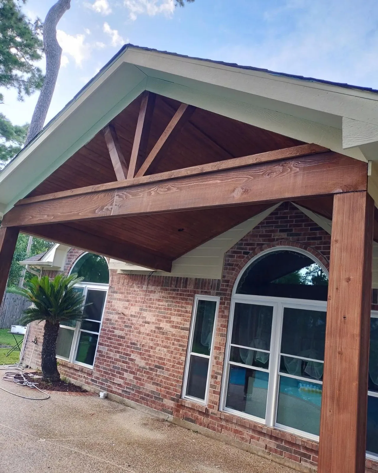 Stained tongue-and-groove cedar gable over a brick patio in Katy, Texas