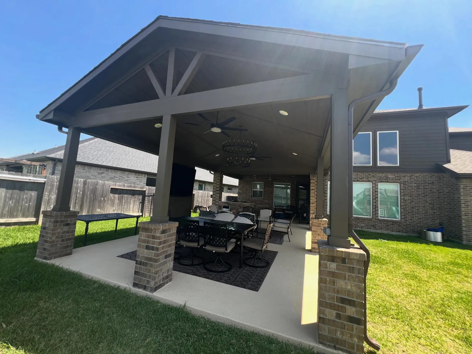 Gabled patio cover with brick columns in a Katy backyard